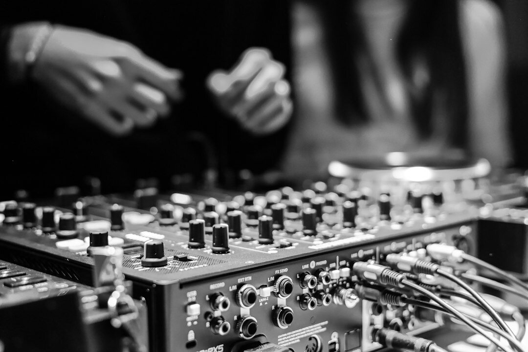 Audio engineer adjusting faders on a sound mixing console